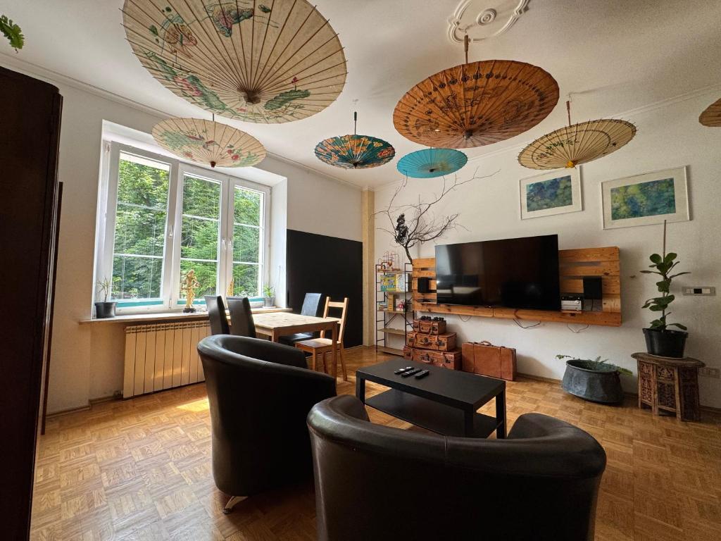 a living room with umbrellas hanging from the ceiling at Za Rogiem in Sandomierz