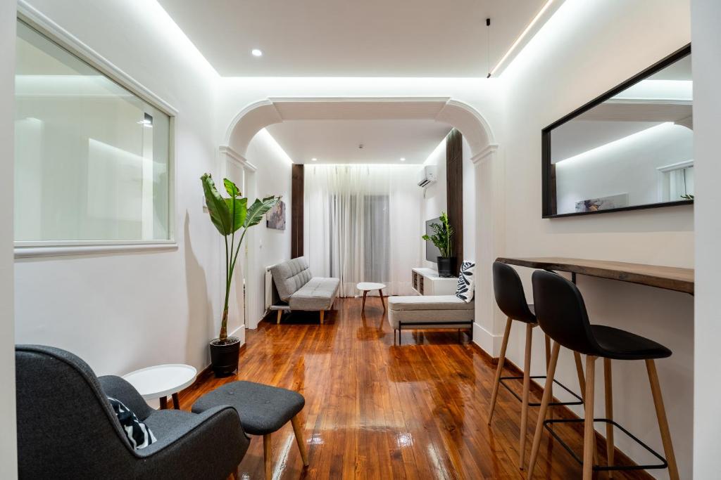 a living room with chairs and a bar with a mirror at Magnus Apollo in Thessaloniki