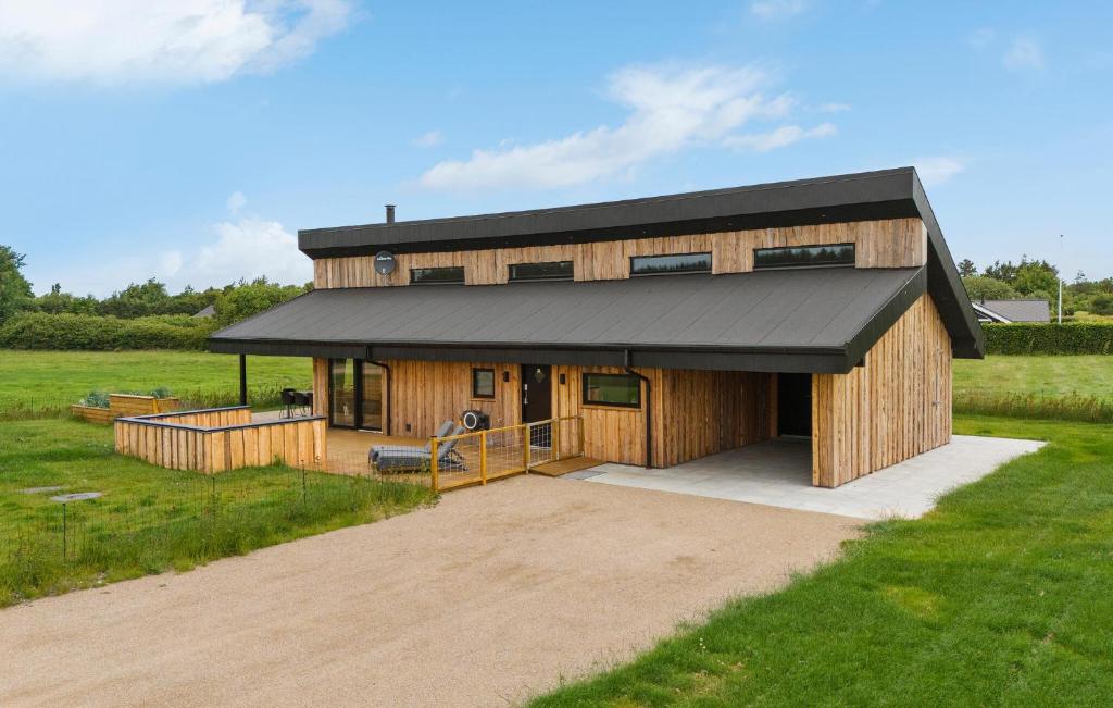 a large wooden house with a black roof at 3 Bedroom Awesome Home In Tarm - P52739 in Tarm