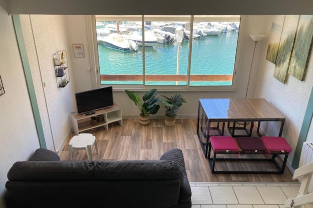 un salon avec un canapé et une table dans l'établissement Duplex apartment facing the port, à Frontignan
