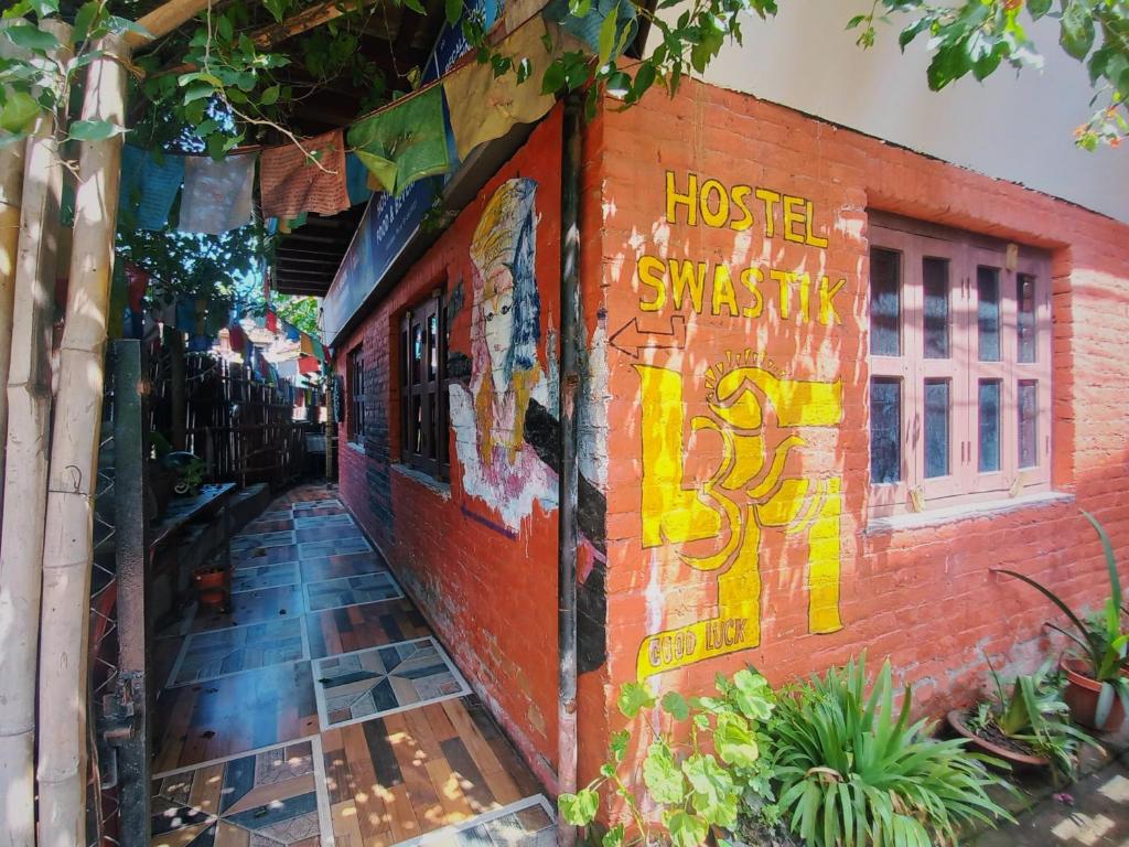 Un edificio de ladrillos con algunos grafitis. en Hostel Swastik, en Bhaktapur