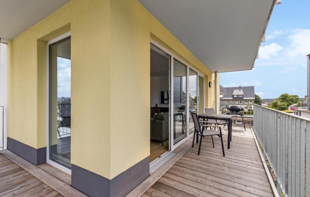 a yellow house with a balcony with a table and chairs at Gebirgsresort Winterberg in Winterberg