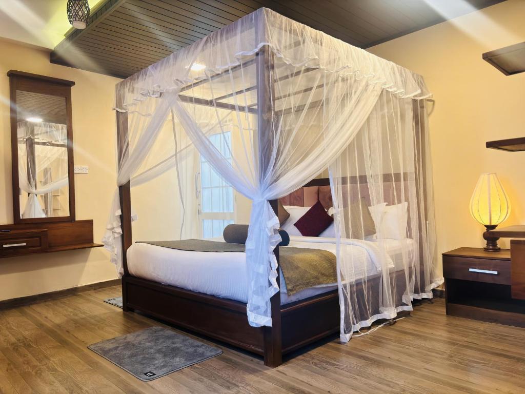 a bedroom with a canopy bed with white curtains at Hill Cool Hotel &amp; Restaurant in Hatton
