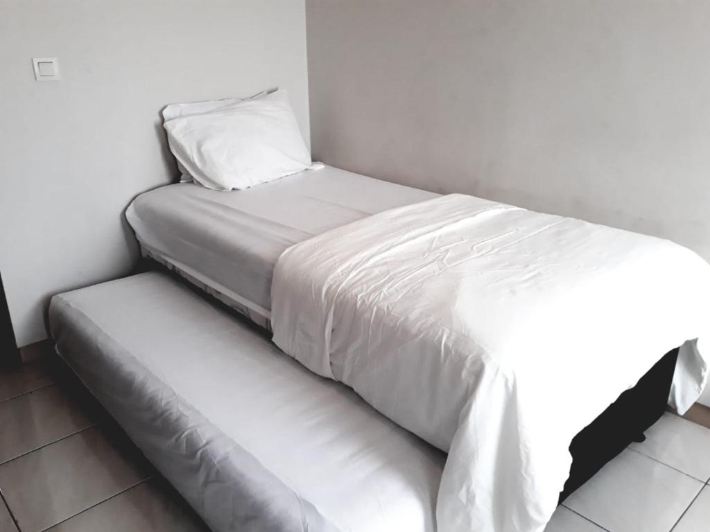 een wit bed met een kussen erop bij opulen view in Rawabugel