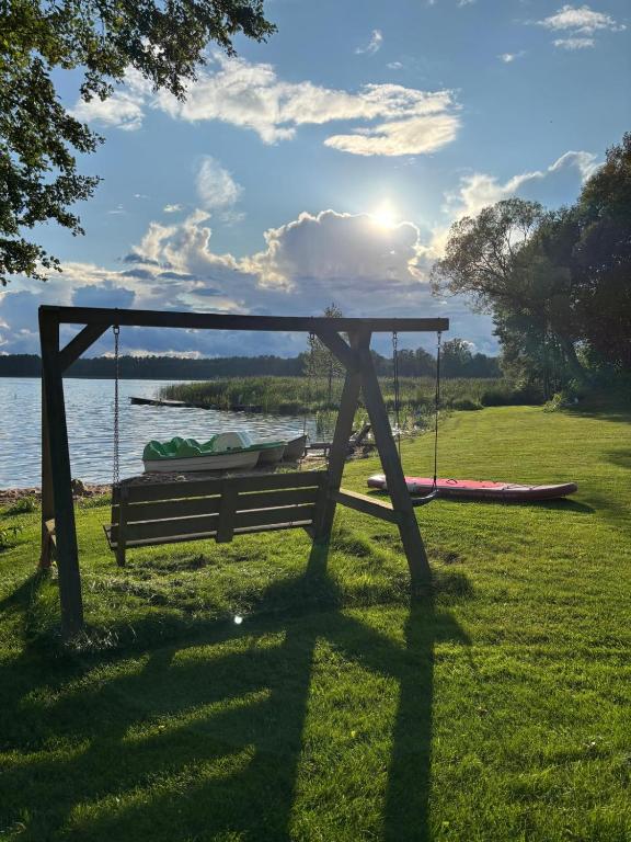 a swing in the grass next to a lake at Biała Czapla in Augustów