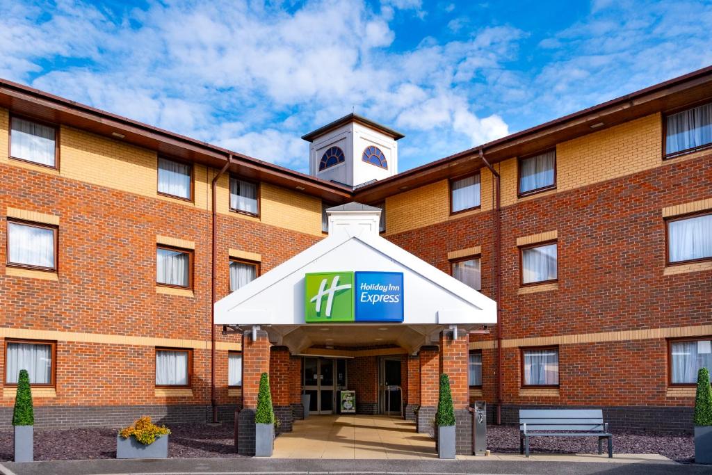 a large brick building with a clock tower on top at Holiday Inn Express Taunton East by IHG in Taunton