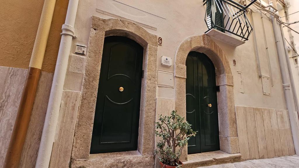 two green doors on the side of a building at Borgo di mare in Gaeta