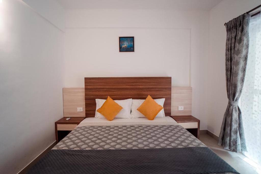 une chambre avec un lit avec des oreillers orange dans l'établissement Ocean Whisper Goa, à Jāmb