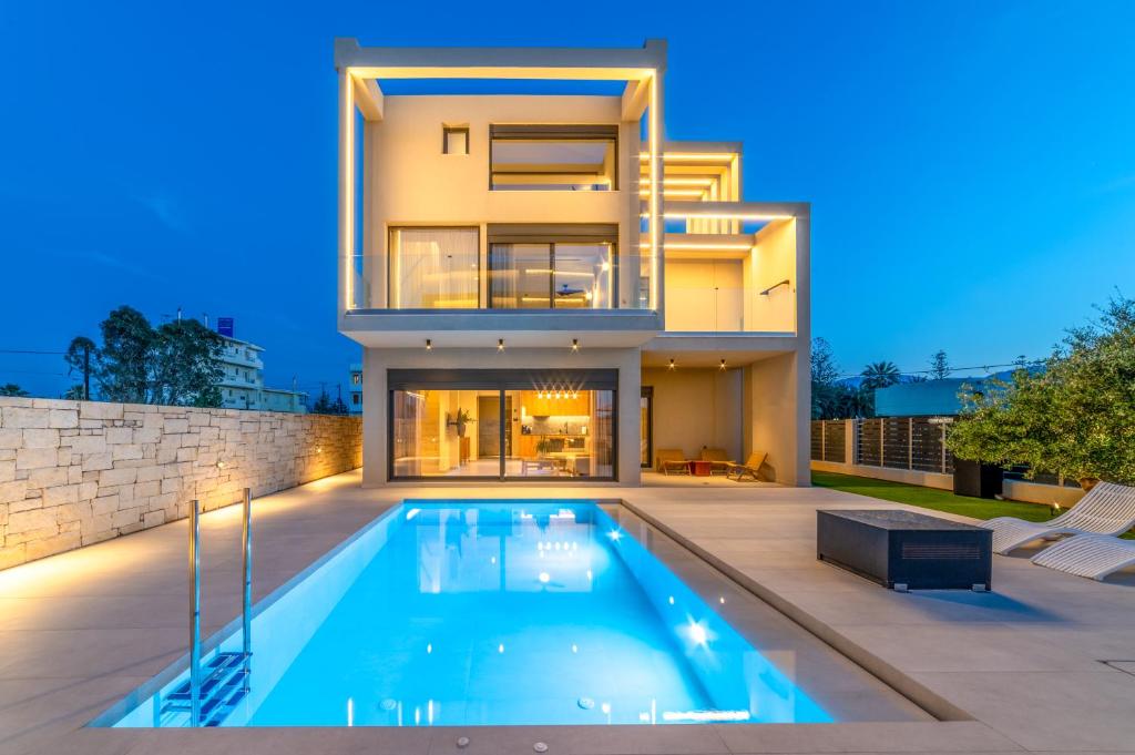 a house with a swimming pool in front of it at Kooba Villas in Gázion