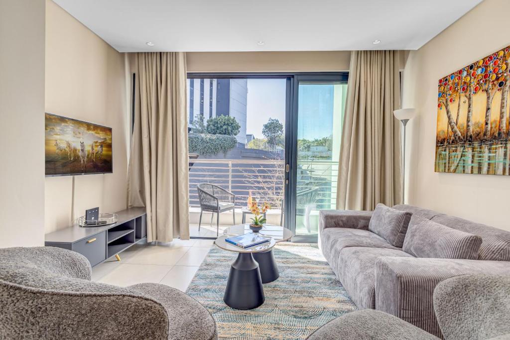ein Wohnzimmer mit Sofa und Tisch in der Unterkunft The Terrace101- 2 Bed, Sandton in Johannesburg