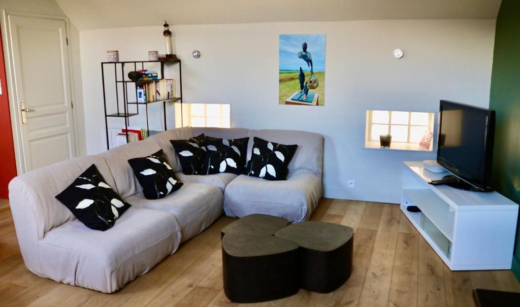 a living room with a couch and a tv at La marée in Étaples