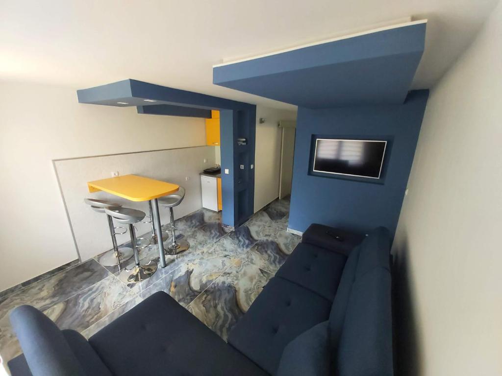 a living room with a blue couch and a table at Apartmani Pelivan in Soko Banja