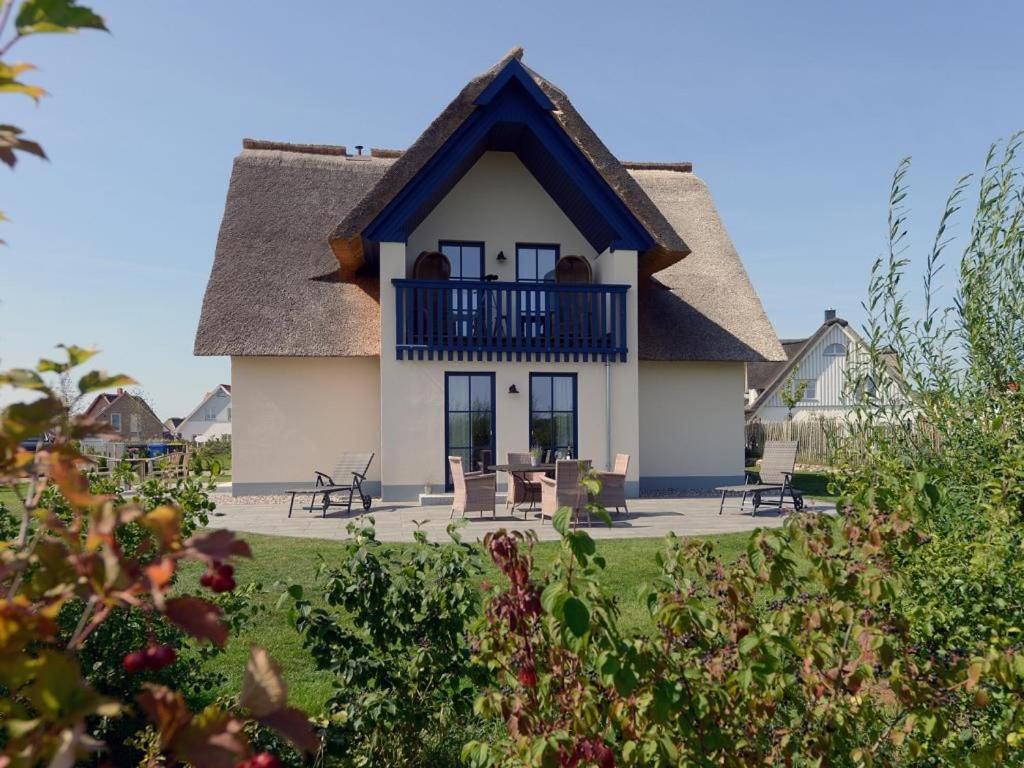 a house with a thatched roof and a balcony at Nausikaa's- Fleur de Lis in Groß Schwansee