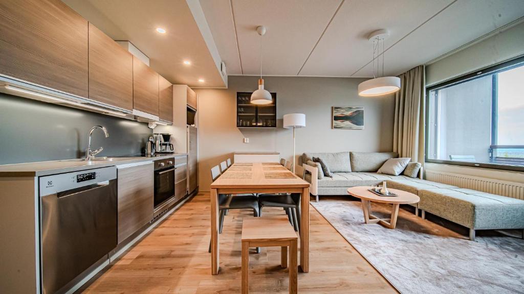a kitchen and living room with a table and a couch at Ylläs Chalets 4101 in Ylläsjärvi