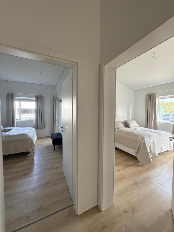 a large mirror in a bedroom with two beds at Luxury Villa Dynskogar Hveragerdi in Hveragerði