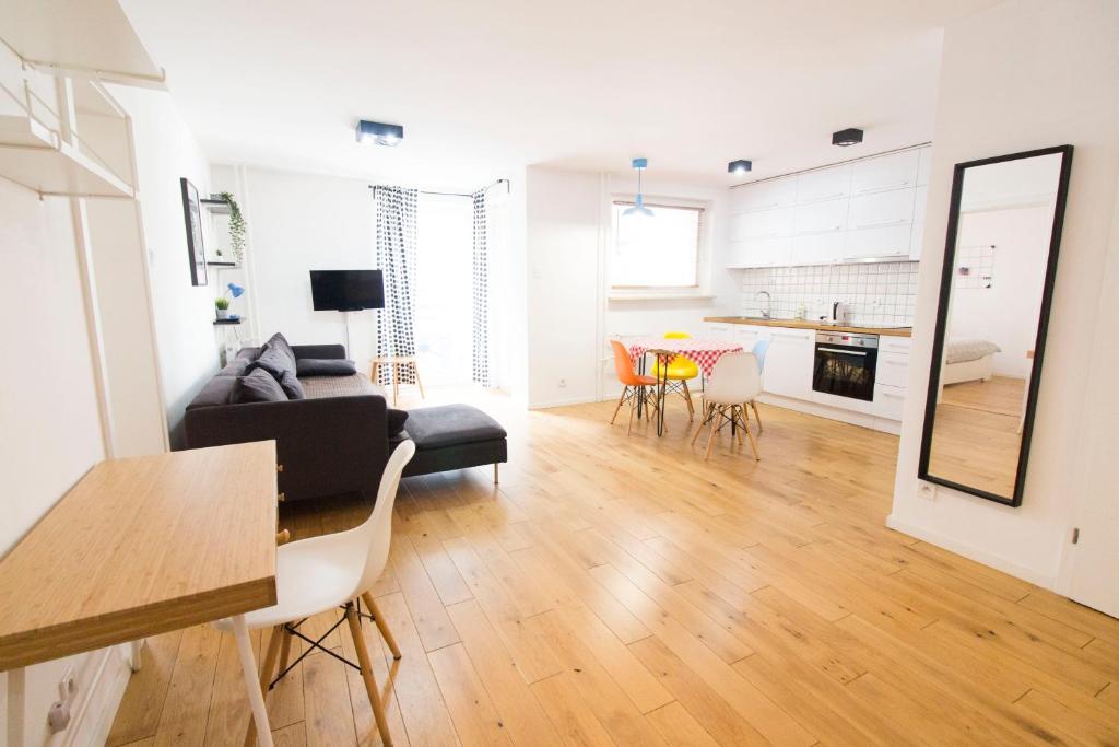 a living room with a black couch and a table at HAPPYESTATE ul Biskupia 3 min do Rynku in Wrocław