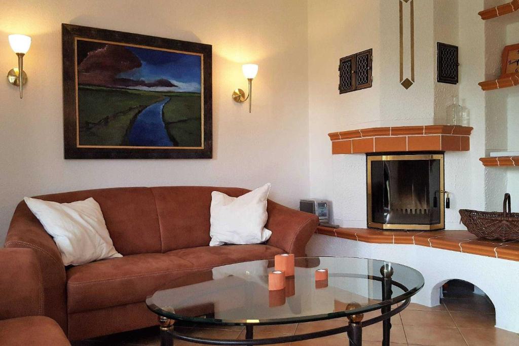 een woonkamer met een bank en een glazen tafel bij Hochstieg 32, Gonska, Haushälfte in Nieblum