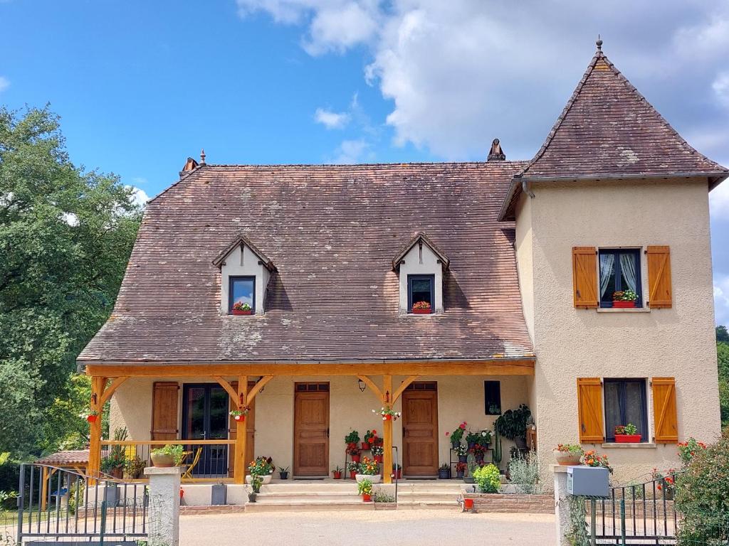 une grande maison blanche avec un toit marron dans l'établissement Moulin de Latouille, à Latouille-Lentillac