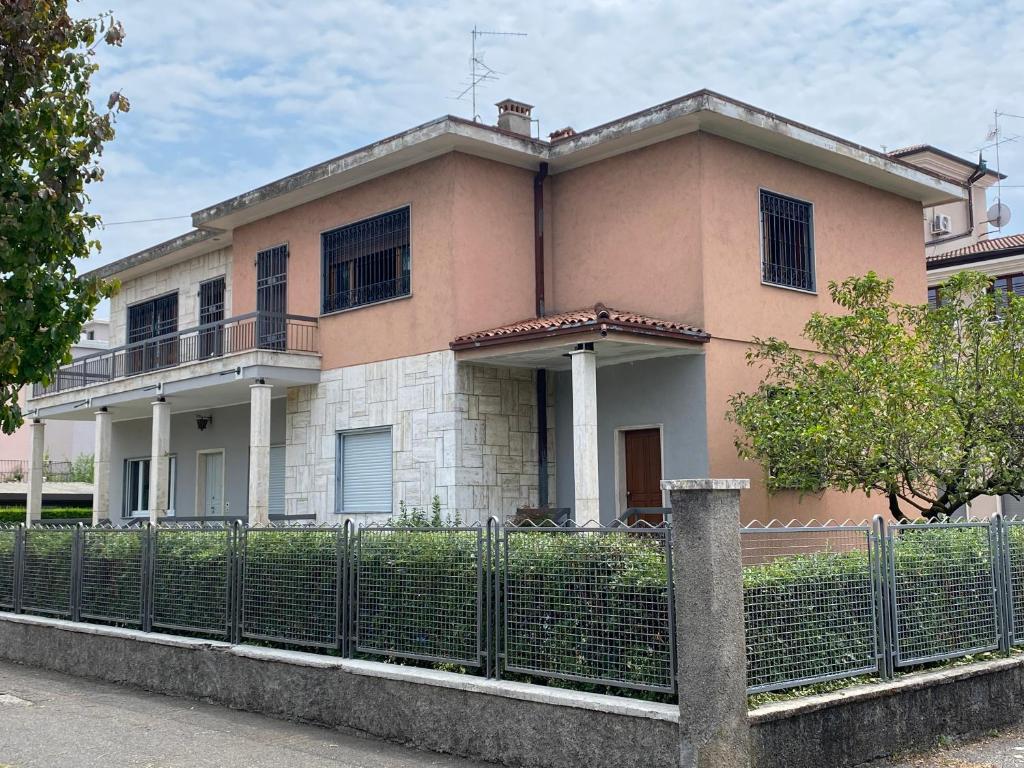 a pink house with a fence in front of it at La VILLA REGAL in Brescia