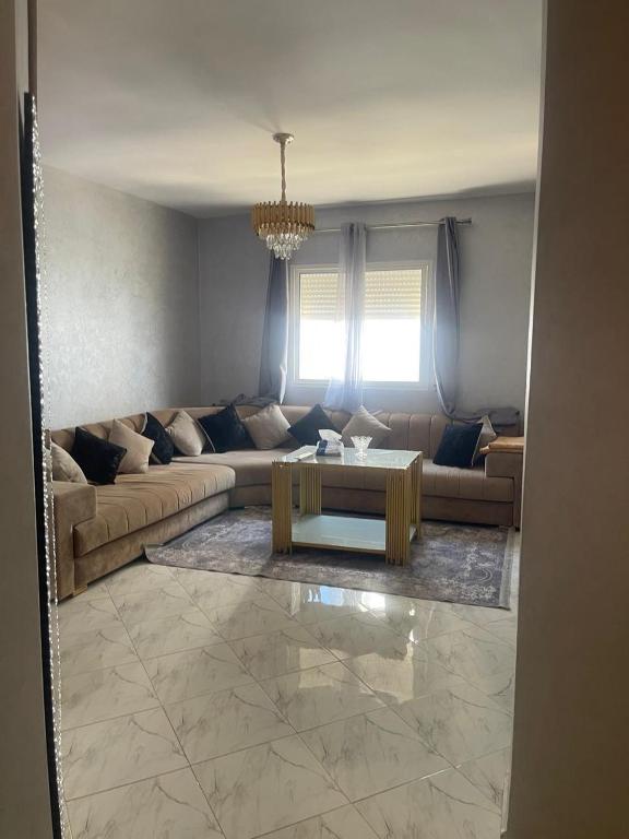 Una sala de estar con un sofá y una mesa de café. en appartement de luxuse, en Alhucemas