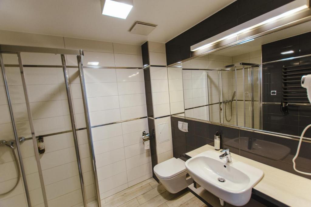 a bathroom with a toilet and a sink and a shower at VacationClub - BORMIO Apartament 17 in Sienna
