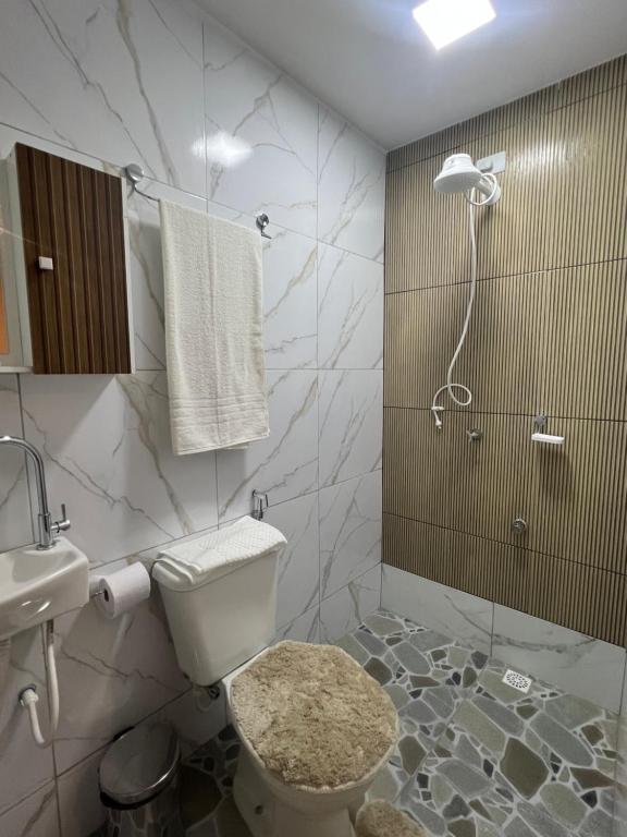 een badkamer met een douche, een toilet en een wastafel bij Manaira Suite 03 com 2 camas de solteiro ou 1 de casal in João Pessoa