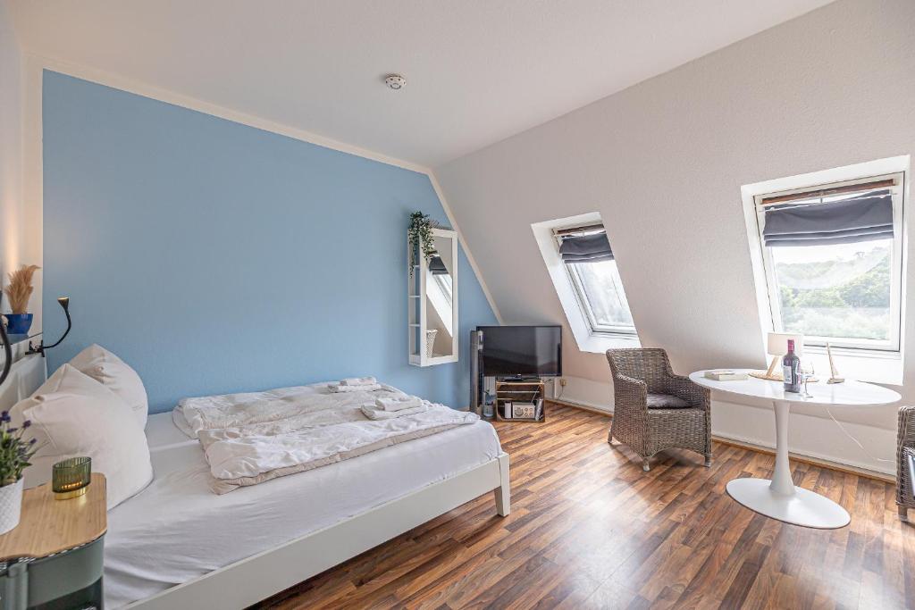 a bedroom with a bed and a table and a tv at fewo1846 - Strandresidenz Wassersleben AHOI - strandnahes Studioapartment im Dachgeschoss in Harrislee