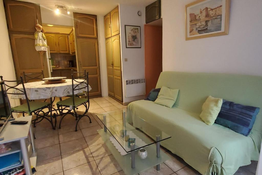 un salon avec un canapé vert et une table dans l'établissement Centrally located apartment with swimming pool, à Fréjus