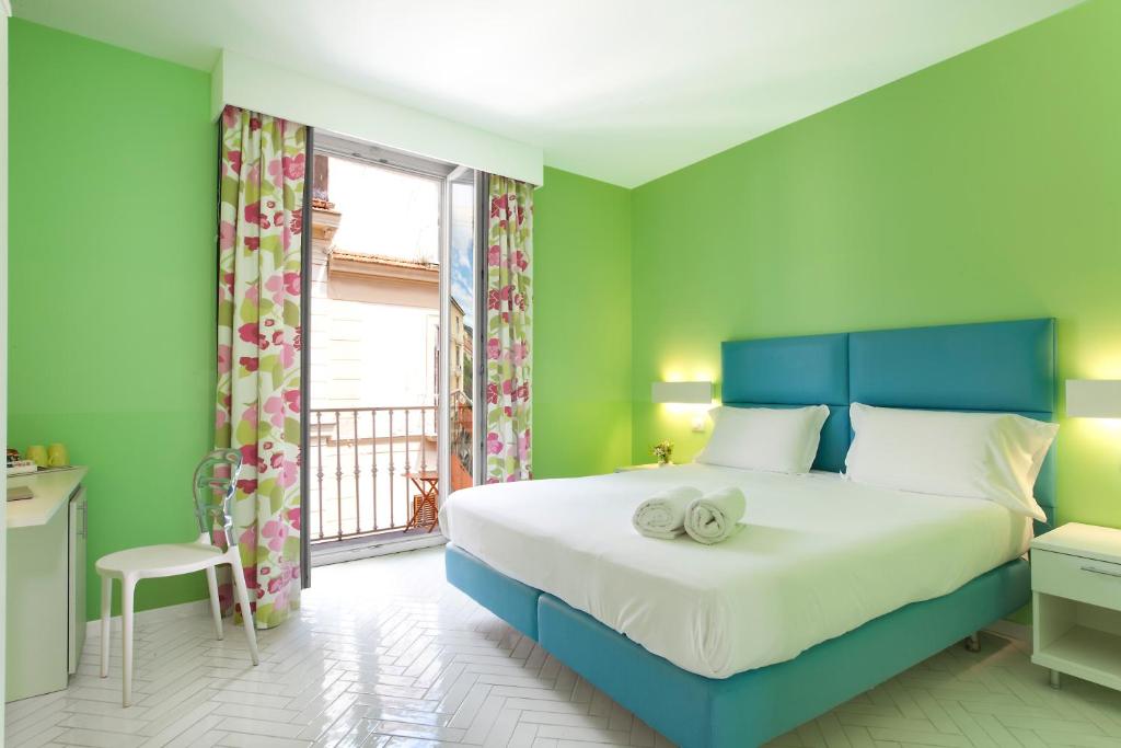 ein Schlafzimmer mit einem blauen Bett und einem Fenster in der Unterkunft Palazzo Tasso in Sorrent