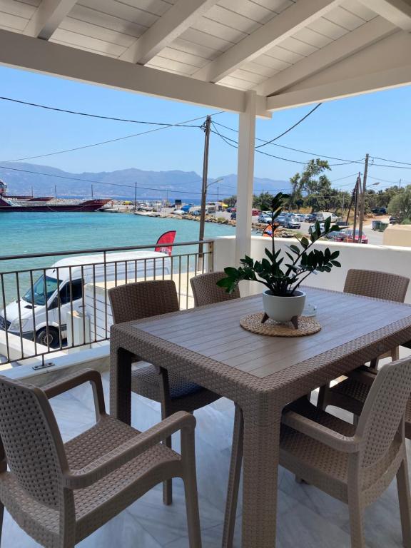 a table and chairs on a balcony with the water at Porto Mare Apartment in Elafonisos