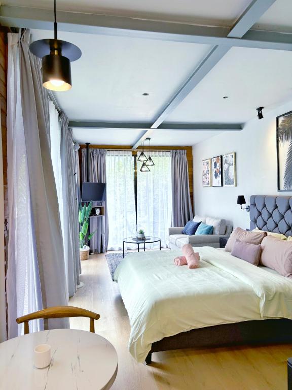 a bedroom with a large bed with a pink stuffed animal on it at Granny's Woods Cottage in Ranau