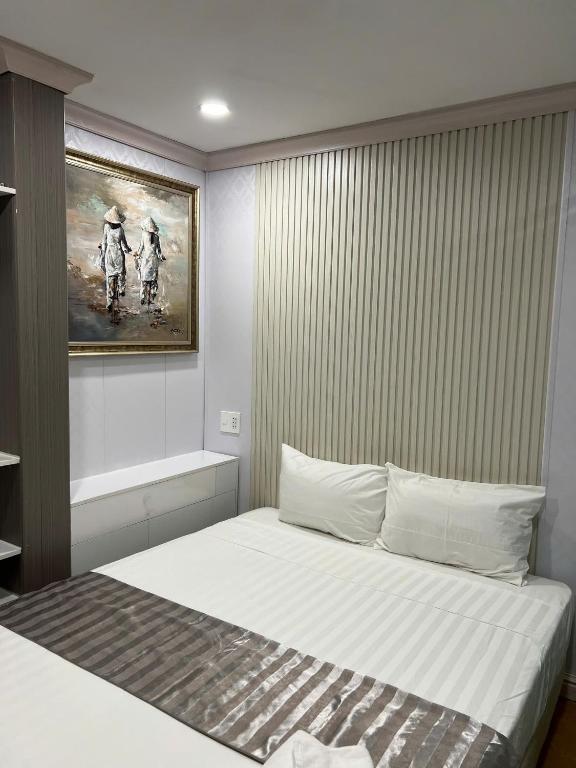 a bedroom with a bed with a painting on the wall at THU's APARTMENT near Ben Thanh Market in Ho Chi Minh City