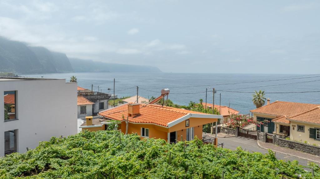 a group of houses on a hill next to the ocean at Coastal São Vicente Mountain & Sea View Hideaway with Free Parking in São Vicente