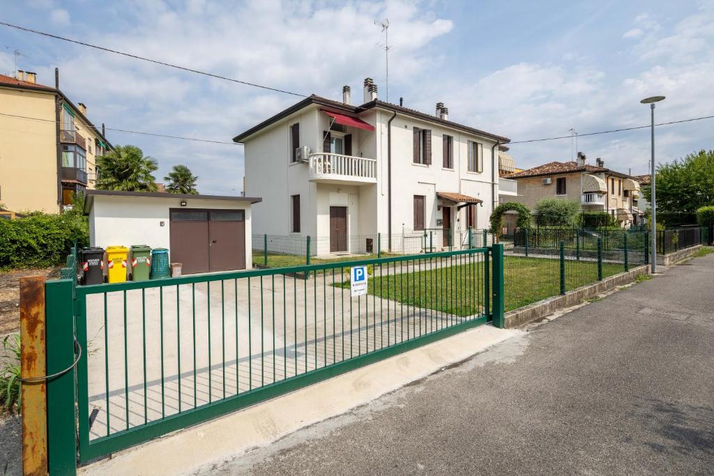 a green fence in front of a white house at BBConegliano Bixio in Conegliano