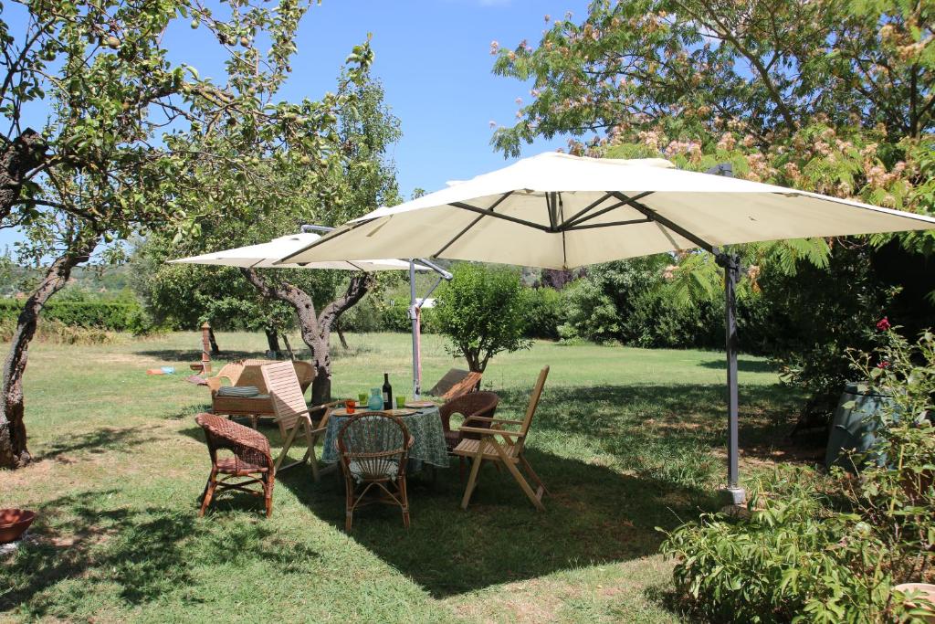 a table and chairs under an umbrella in a yard at Il casale dei tigli in Limite