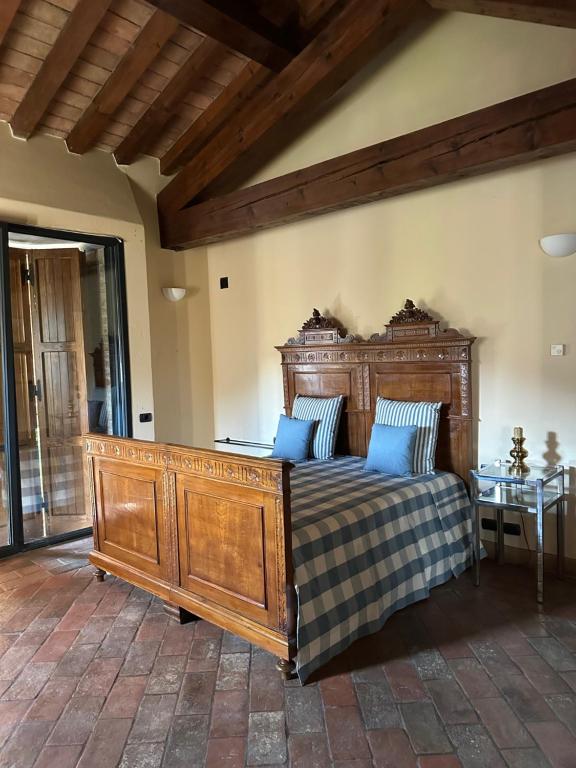 LarzanoにあるNiviano Castelloのベッドルーム1室(大型木製ベッド1台、青い枕付)