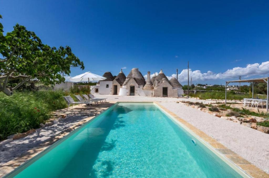 an image of a swimming pool in front of a house at Stylish Trullo Pool Villa in Martina Franca