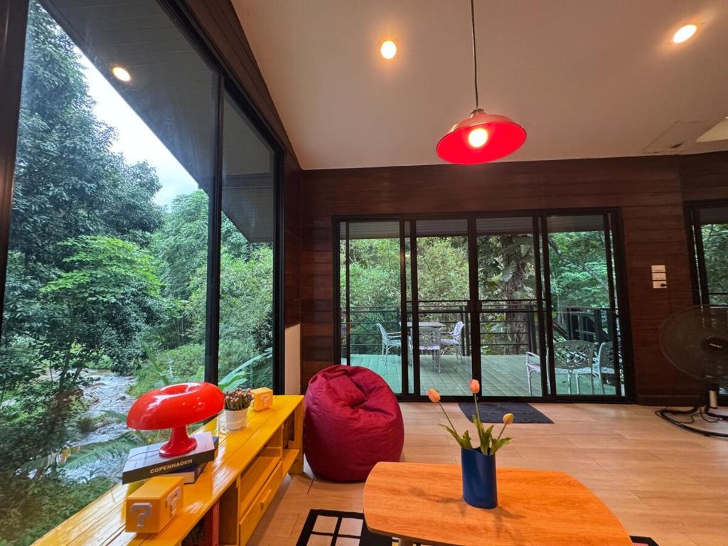 a living room with a large window and a table at Top River Nest- Upper Floor 