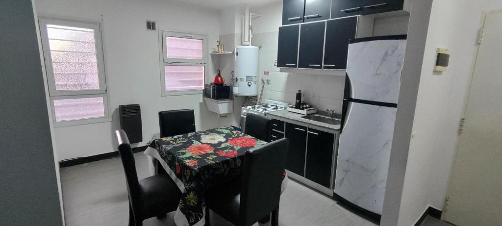 eine kleine Küche mit einem Tisch mit Blumen darauf in der Unterkunft Departamento para dos personas in Río Gallegos