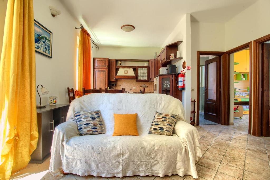 a living room with a white couch with pillows on it at Fronte ciclabile con posto per auto e biciclette in Imperia