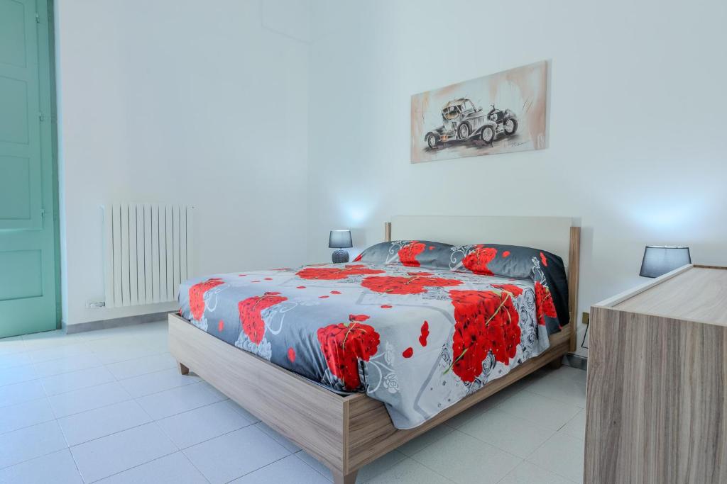 - une chambre avec un lit et une couette rouge et blanche dans l'établissement Dimora Isabella, à Lecce
