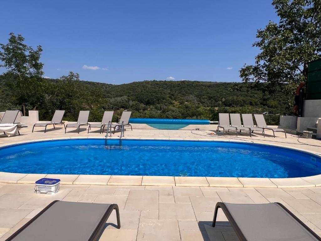 a swimming pool with chairs and a table at Casa Maria Sarata Monteoru in Sărata-Monteoru