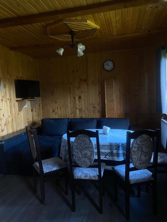 マイコリチンにあるHutsulka Houseのテーブルと椅子と時計のあるダイニングルーム