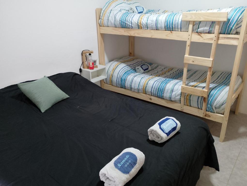 a bedroom with two bunk beds and towels on a bed at Departamento NAMASTE II in Carhué