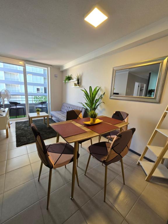 a living room with a wooden table and chairs at Espléndido y central Departamento Familiar in Rancagua