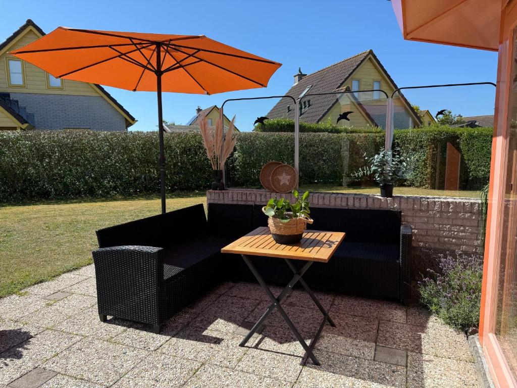a patio with a table and an umbrella at Zeester 189 in Julianadorp
