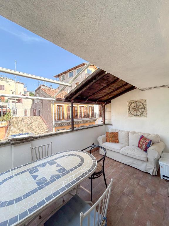 a balcony with a table and a couch at Attic Castel Sant'Angelo - Pantheon in Rome