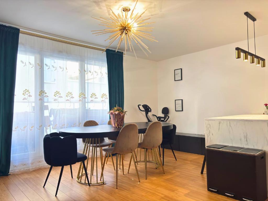 a dining room with a table and chairs at Bezons Golden - 3 chambres - 3min du Tramway #SirDest in Bezons