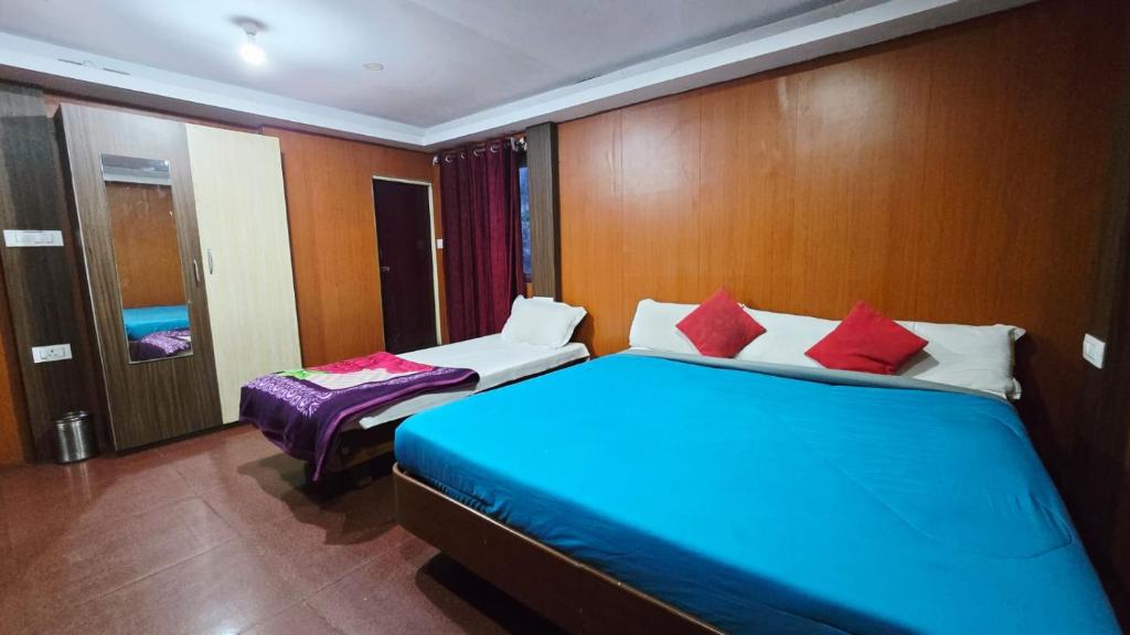 a bedroom with a blue bed and a bench in it at Mananya Cottage Ooty in Ooty