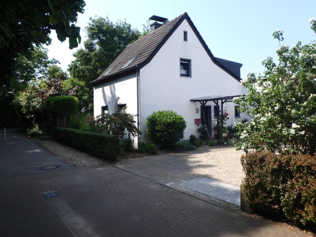 a white house with a black roof on a street at Ferienwohnung Knusperhaus in Xanten